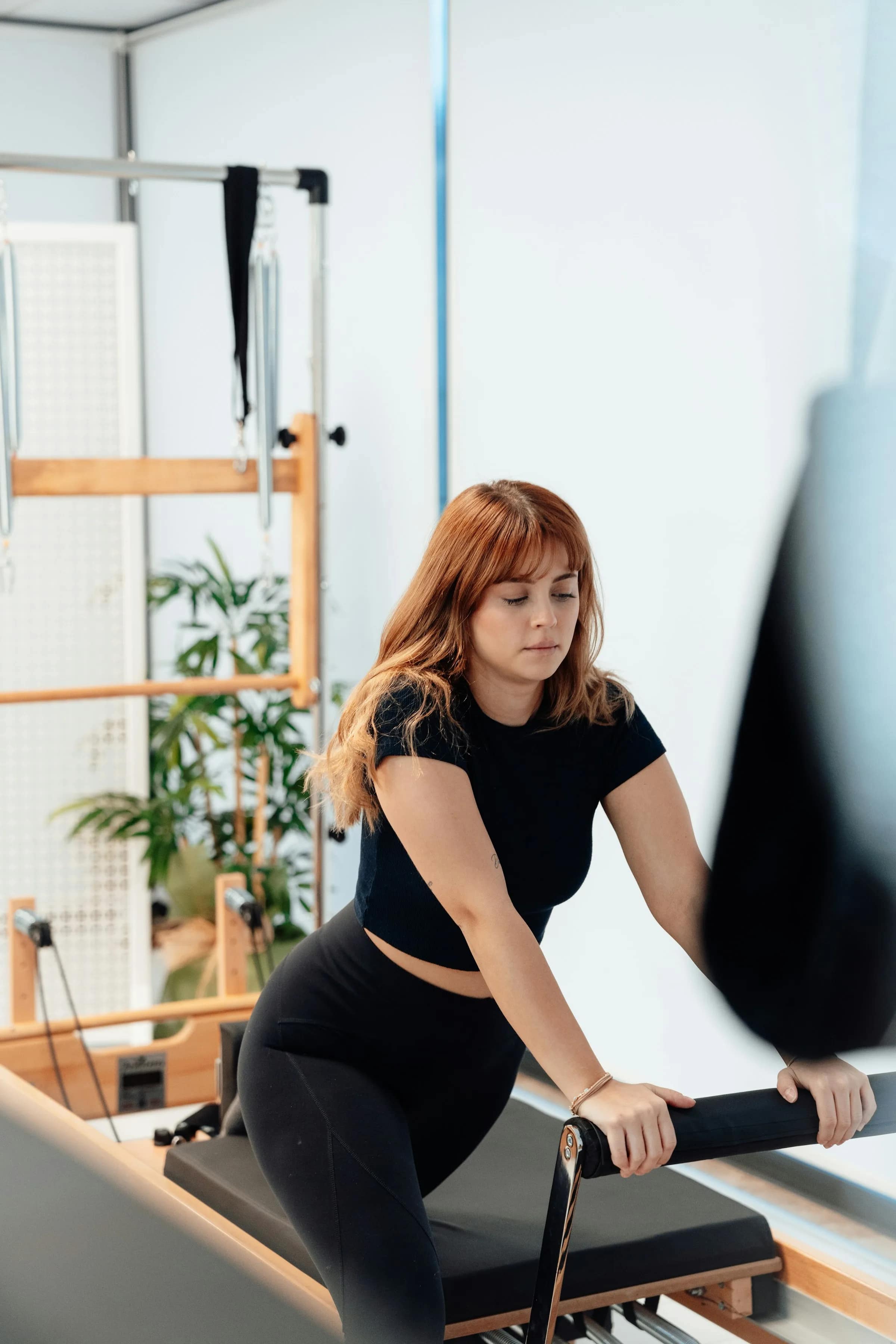 Alessia Ronchi regola le cinghie di un reformer prima della lezione